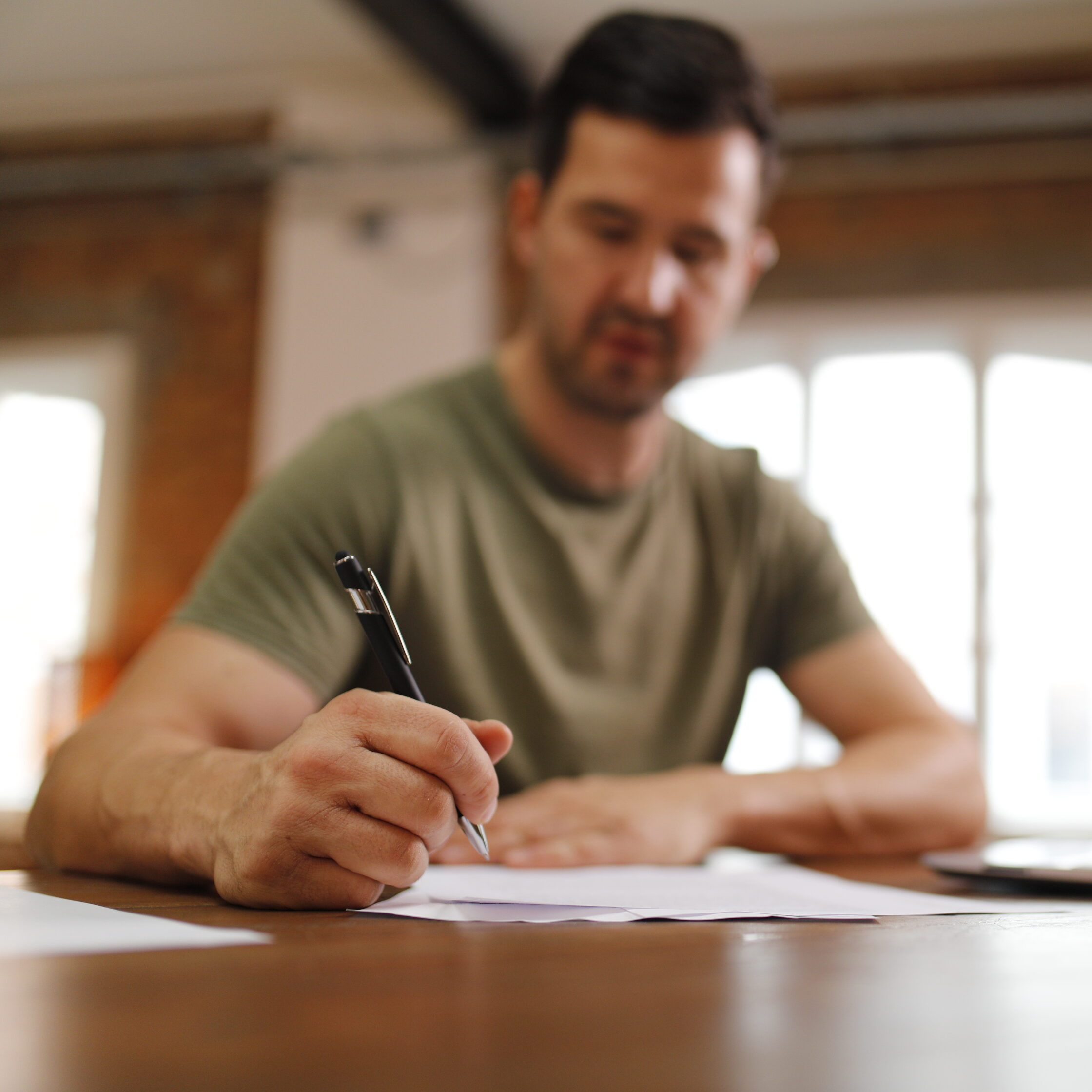 Der Autor arbeitet mit einem Stift in der Hand an seinem ausgedruckten Manuskript.